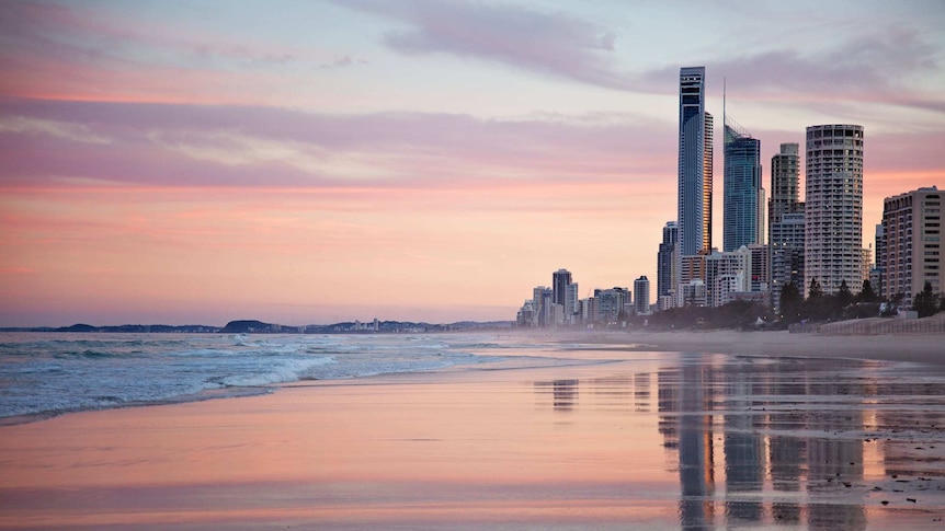 Gold Coast beach and high-rise building skyline during sunset.