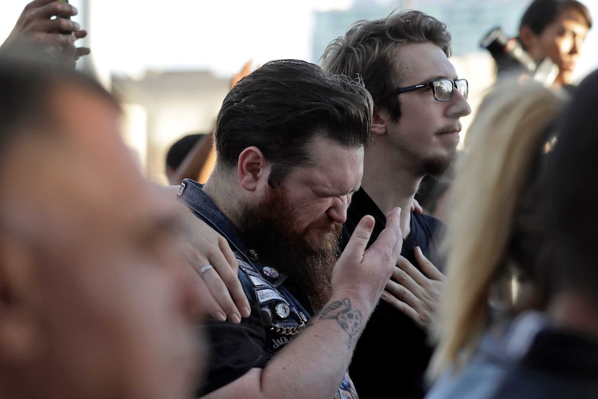 A man is comforted by a friend during a vigil in Las Vegas for victims of the mass shooting.