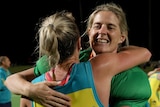 Two Hockeyroos players embrace as they celebrate beating Russia.
