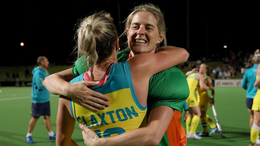 Two Hockeyroos players embrace as they celebrate beating Russia.