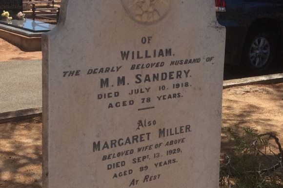 A white gravestone in a rural cemetery with William Sandery's name on it.