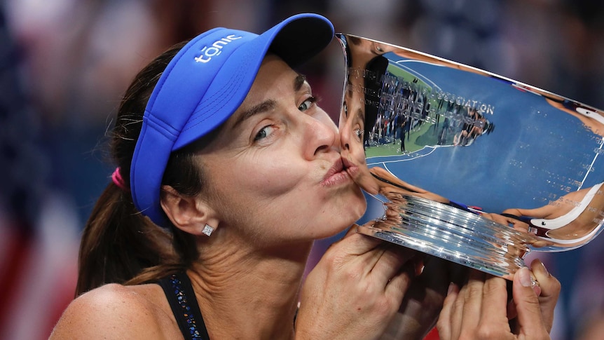 Martina Hingis kisses the US Open women's doubles championship trophy.