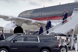 Donald Trump walks down stairs at the back of his plane.