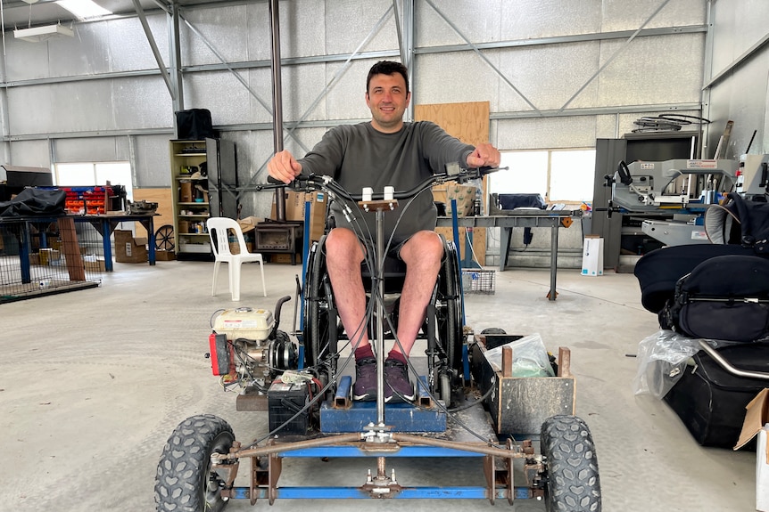 A man on a transport prototype that resembles a go-kart with chair on top