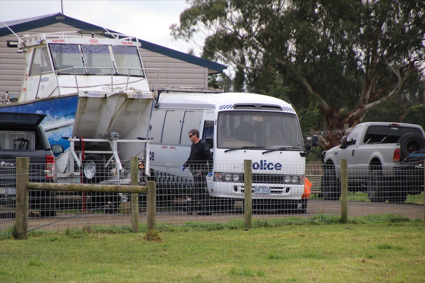 A police van parked at a rural property near a boat up on a trailer, July 2023 