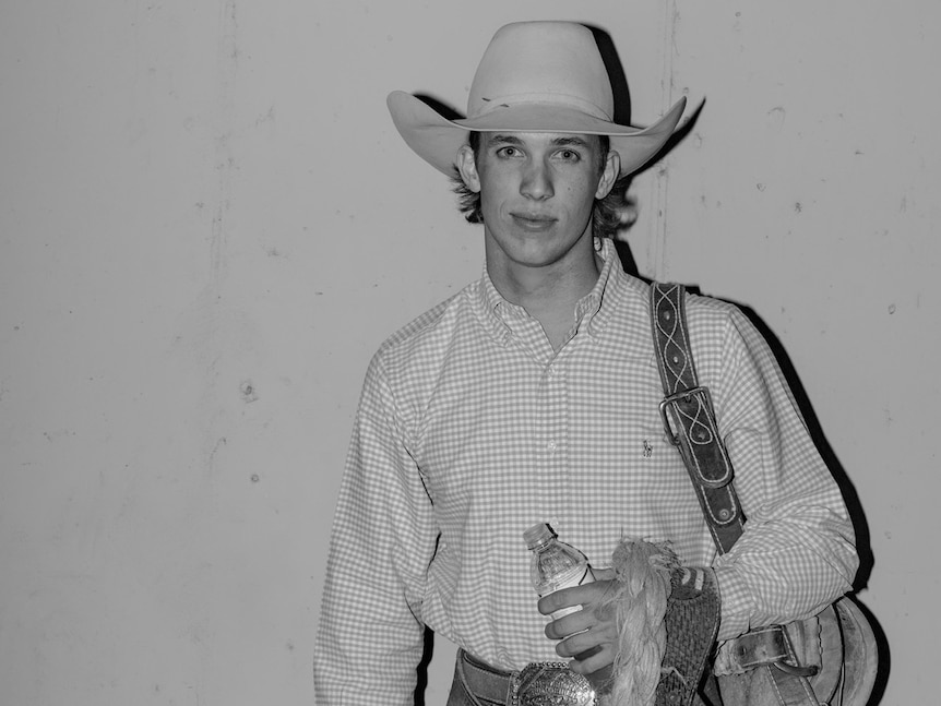 A black and white portrait of a young man in a cowboy outfit.