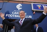Richard Pratt with arms up in air outside Carlton FC club