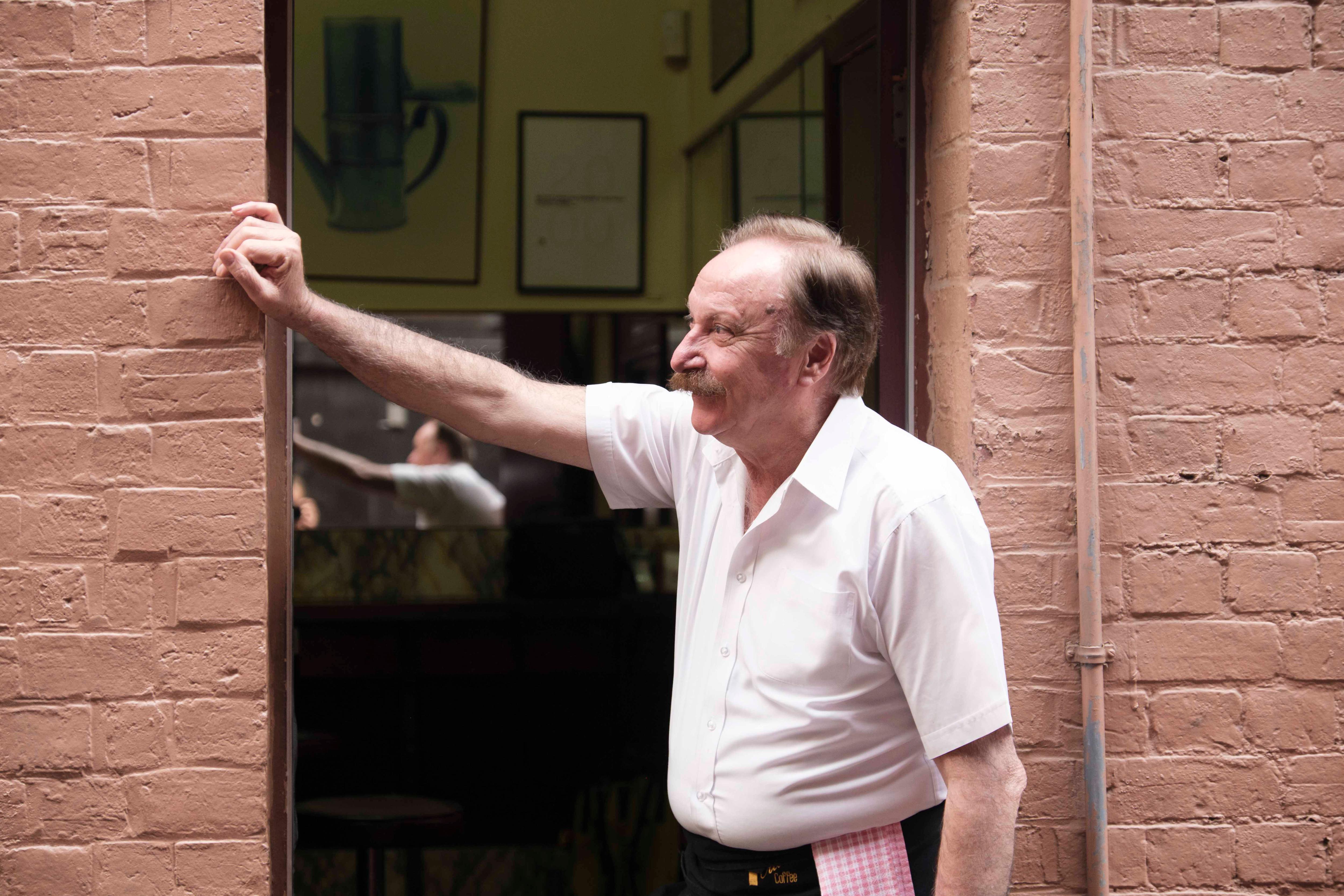 Rocco standing in a doorway leaning against the frame.