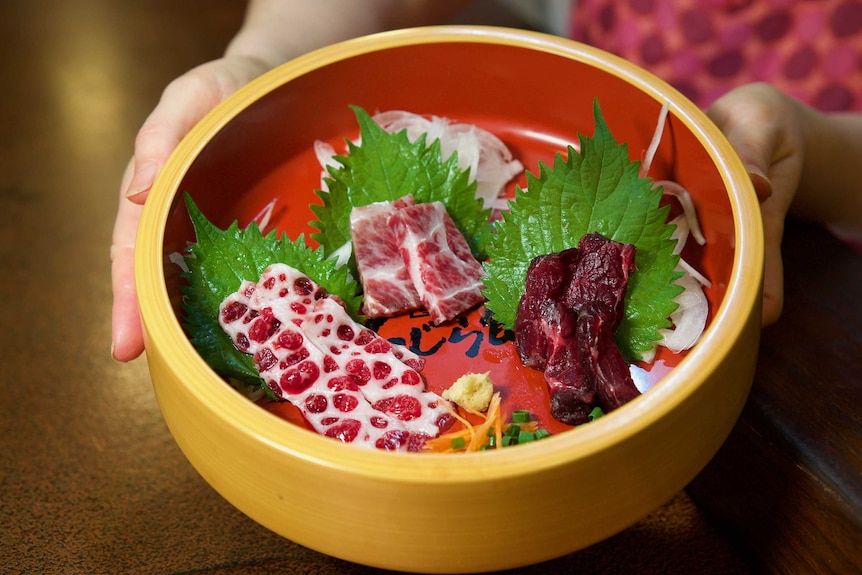A bowl full of whale meat cut into delicate slices