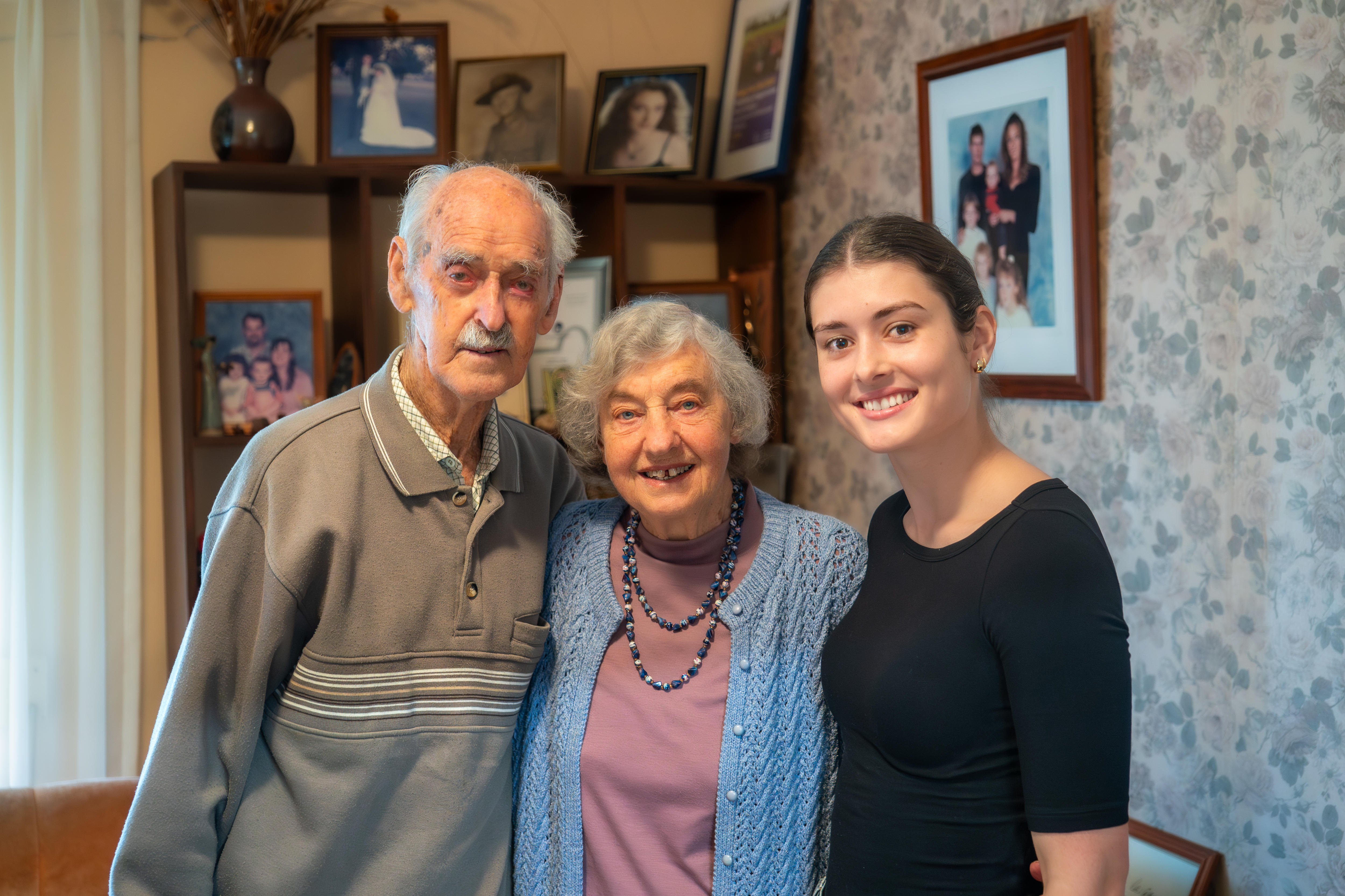 A man, woman and young woman stand side by side. 
