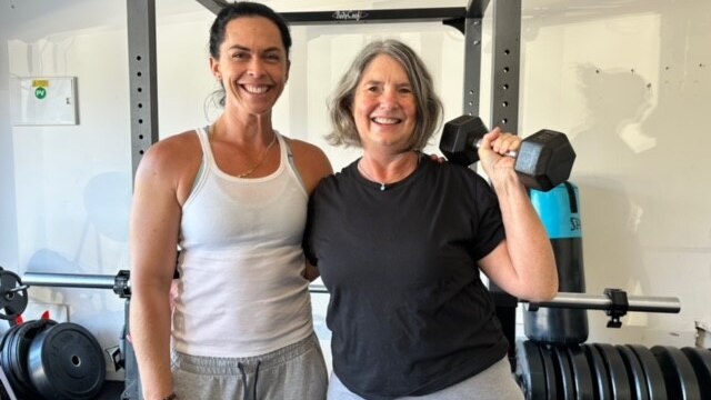 Former ABC Presenter Louise Maher lifts a hand weight with trainer Jenna Fitch