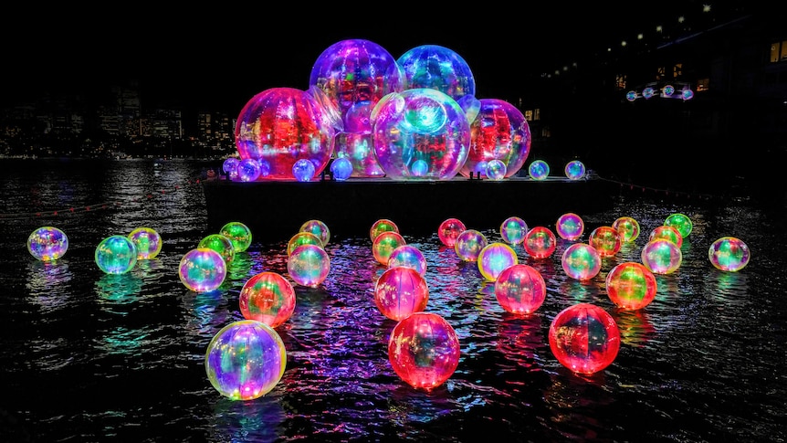 Colourful bubbles on the water and platform in the night
