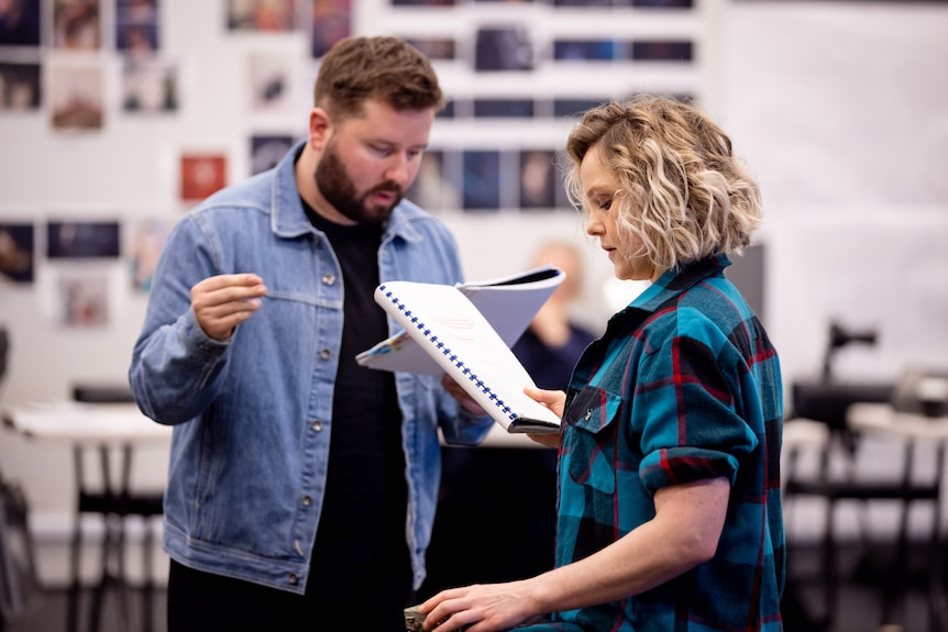 Kip Williams and Eryn-Jean Norvill stand in a rehearsal room, both holding and reading a script.