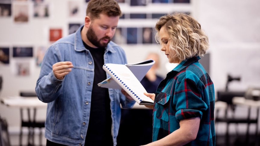 Kip Williams and Eryn-Jean Norvill stand in a rehearsal room, both holding and reading a script.