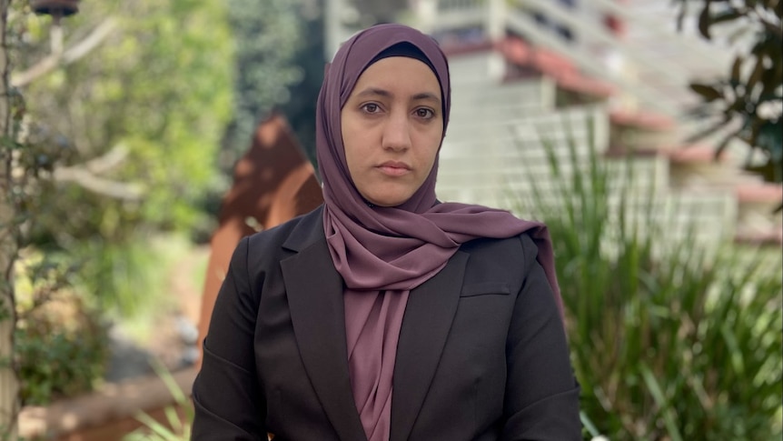 A woman wearing a traditional headscarf and a suit blazer