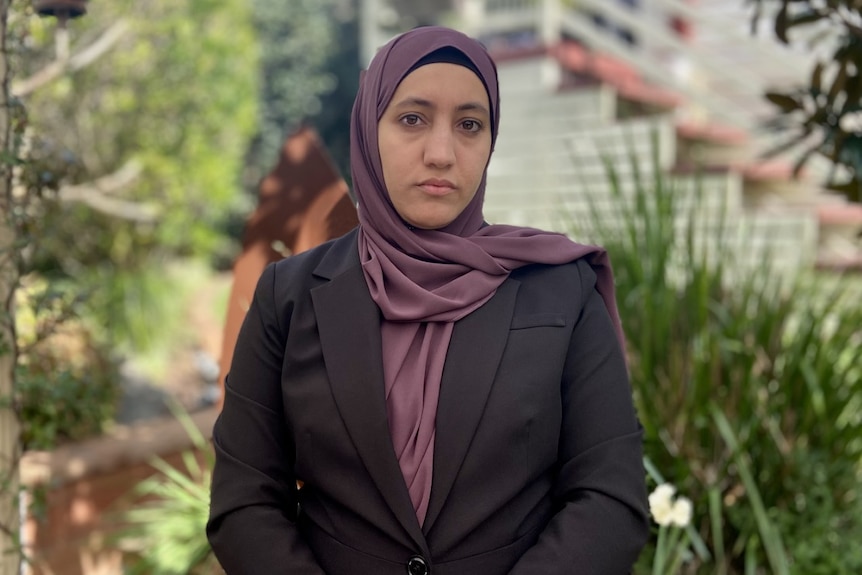 A woman wearing a traditional headscarf and a suit blazer