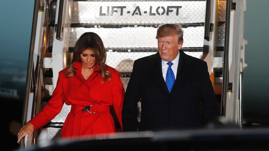 President Trump walks down the airforce one stairs holding wife Melania Trump's hand