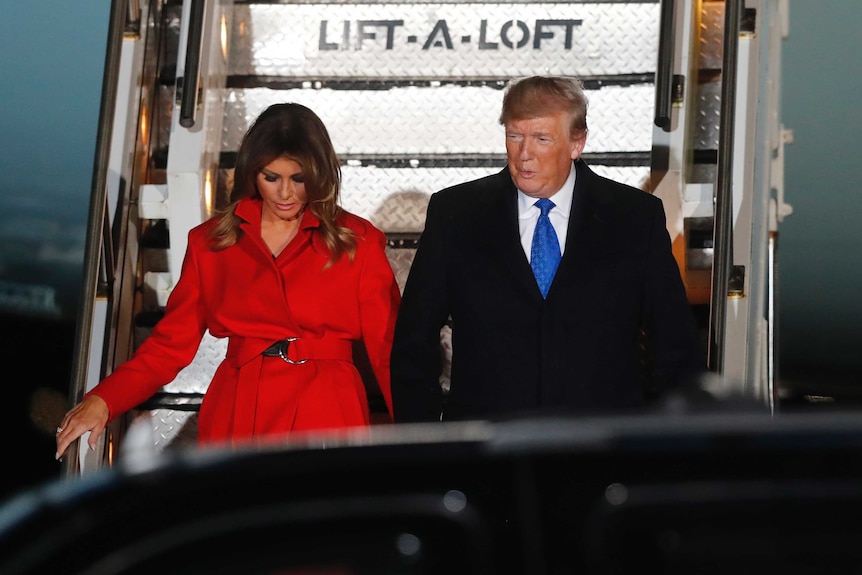 President Trump walks down the airforce one stairs holding wife Melania Trump's hand