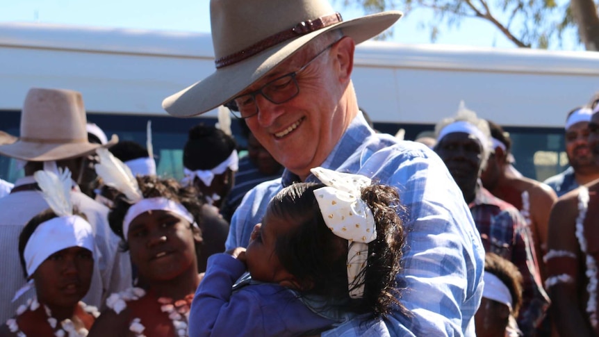 Malcolm Turnbull embraces a child in Tennant Creek