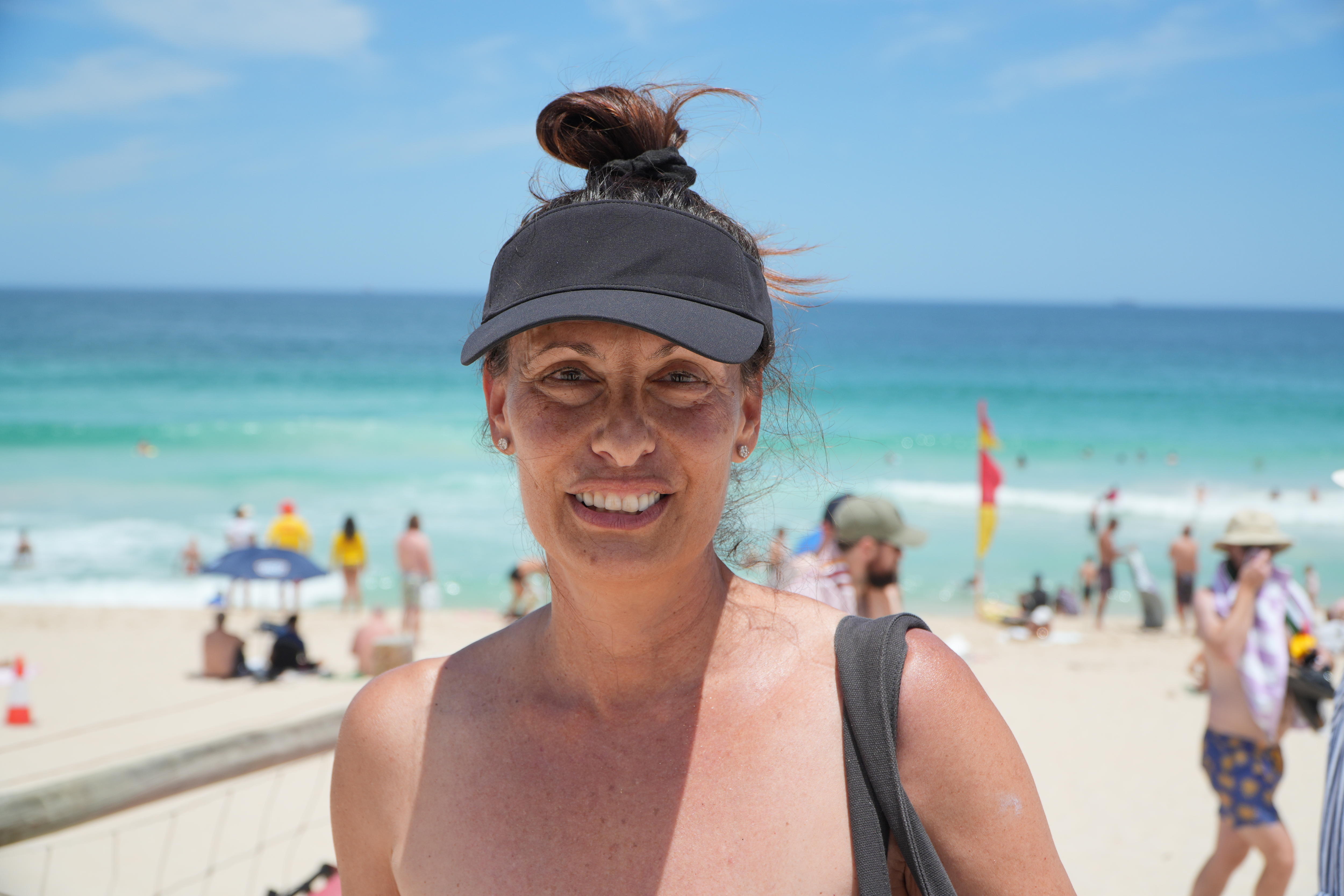 A woman in a dark baseball cap grins. 