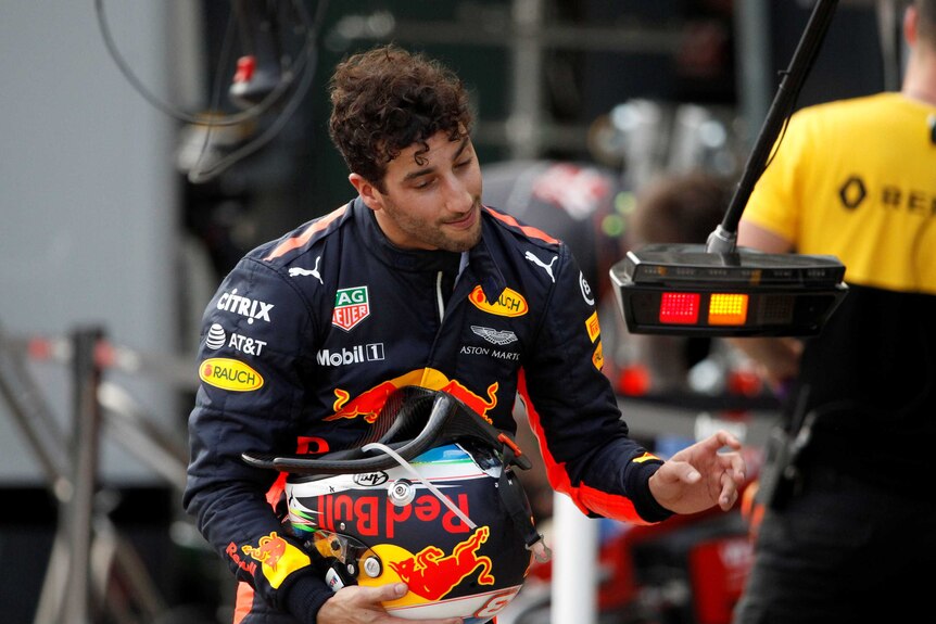 Daniel Ricciardo of Australia walks down pit lane his head to the side