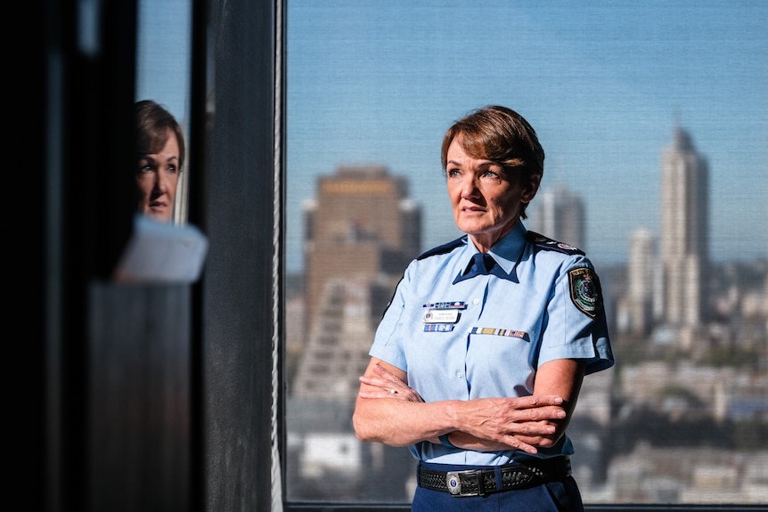 Woman standing arms crossed in front of window