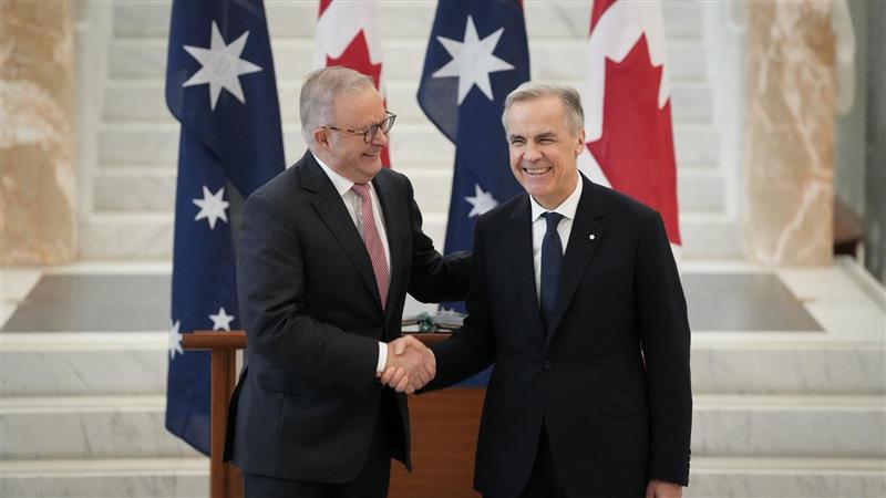 Anthony Albanese smiles, shaking hands with Mark Carney in Canberra. 