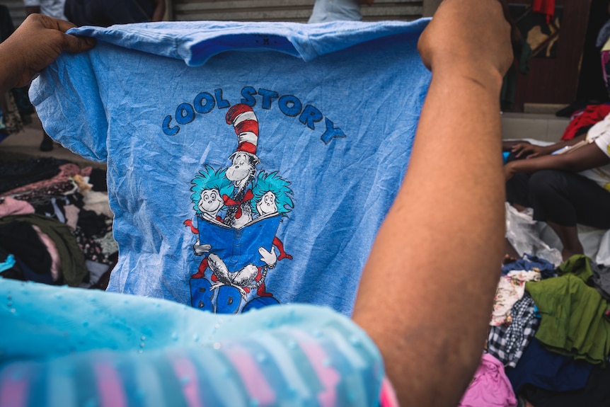 A blue t-shirt being held up.
