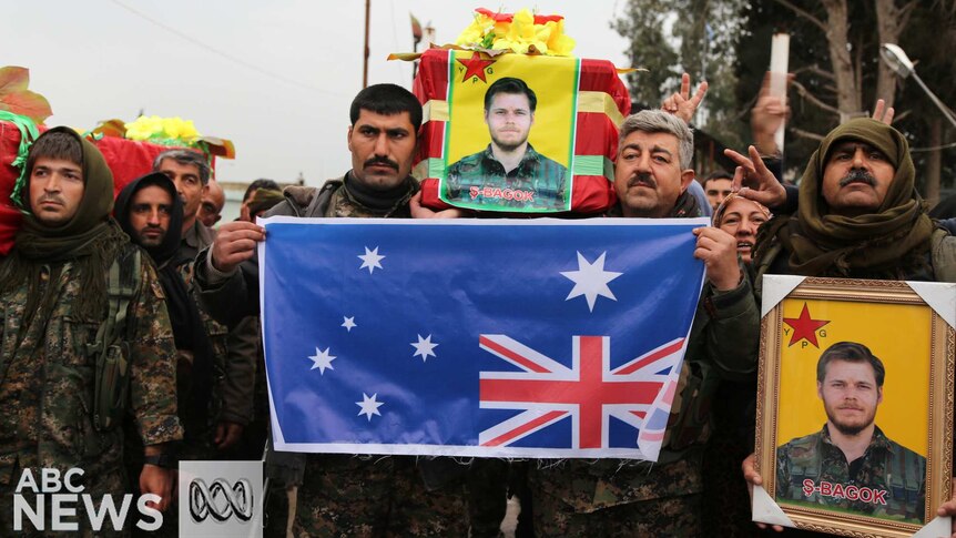 Kurdish fighters carry a coffin and an Australian flag