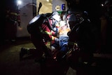 Miners in emergency gear around a stretcher.