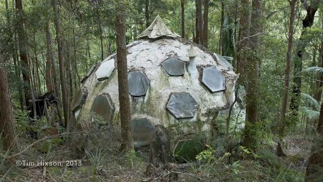 A round-shaped eco home sits amongst trees
