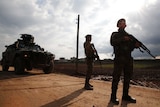 Turkey-backed Syrian fighters stand with guns and tank as they secure a checkpoint