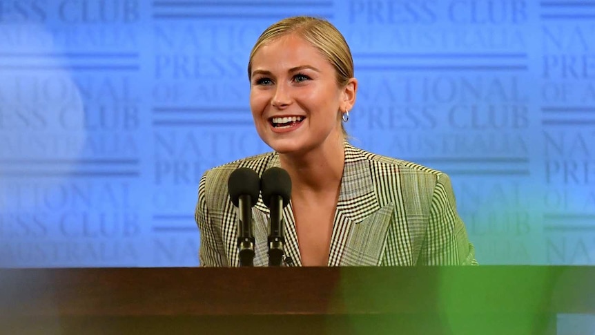 Grace Tame smiles at an audience.