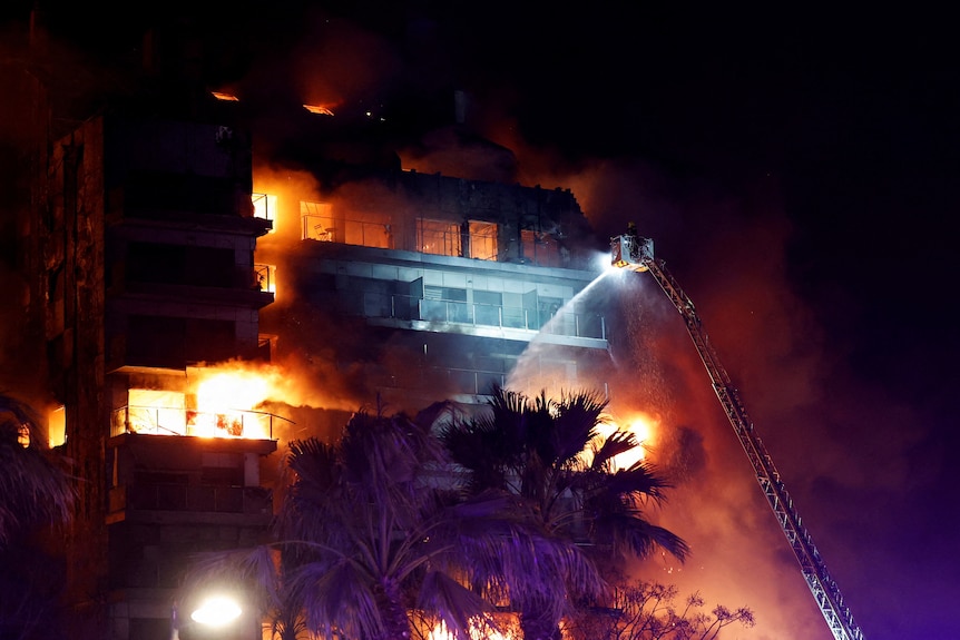 Firefighters work at the scene of a fire at an apartment building in Valencia, Spain.
