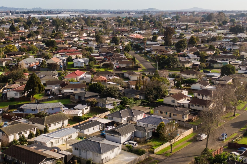 An aerial shot shows rows of houses. 