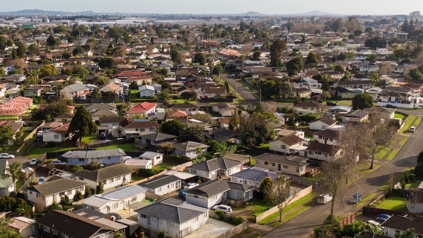 An aerial shot shows rows of houses. 