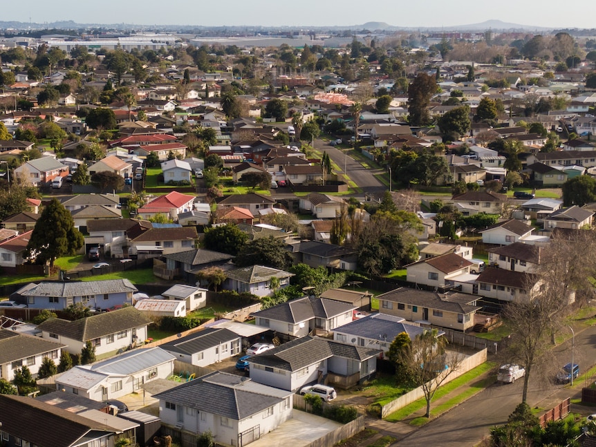 An aerial shot shows rows of houses. 