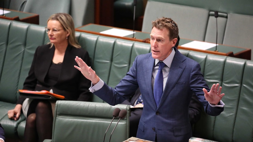 Christian Porter speaks at the despatch box with his arms outstretched. Sussan Ley is sitting behind him