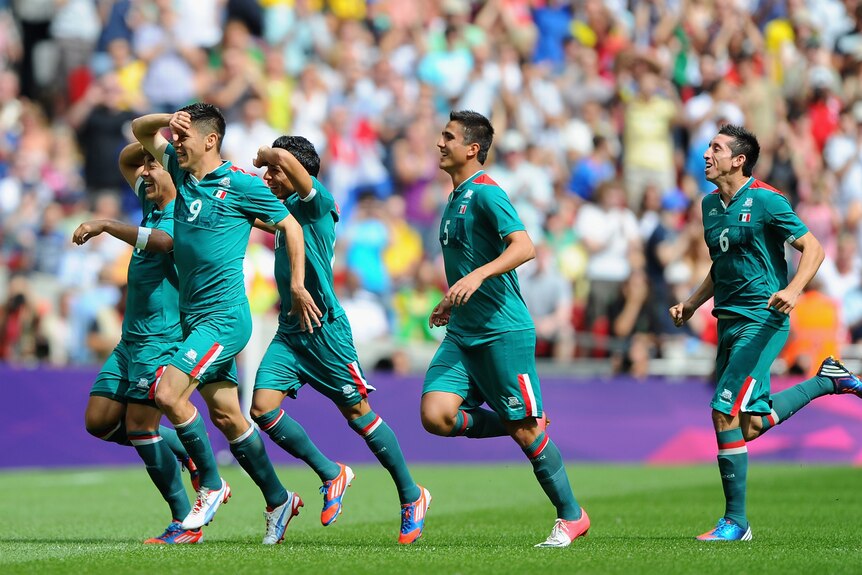 The Mexican team celebrates an early goal in the gold medal football match against Brazil.
