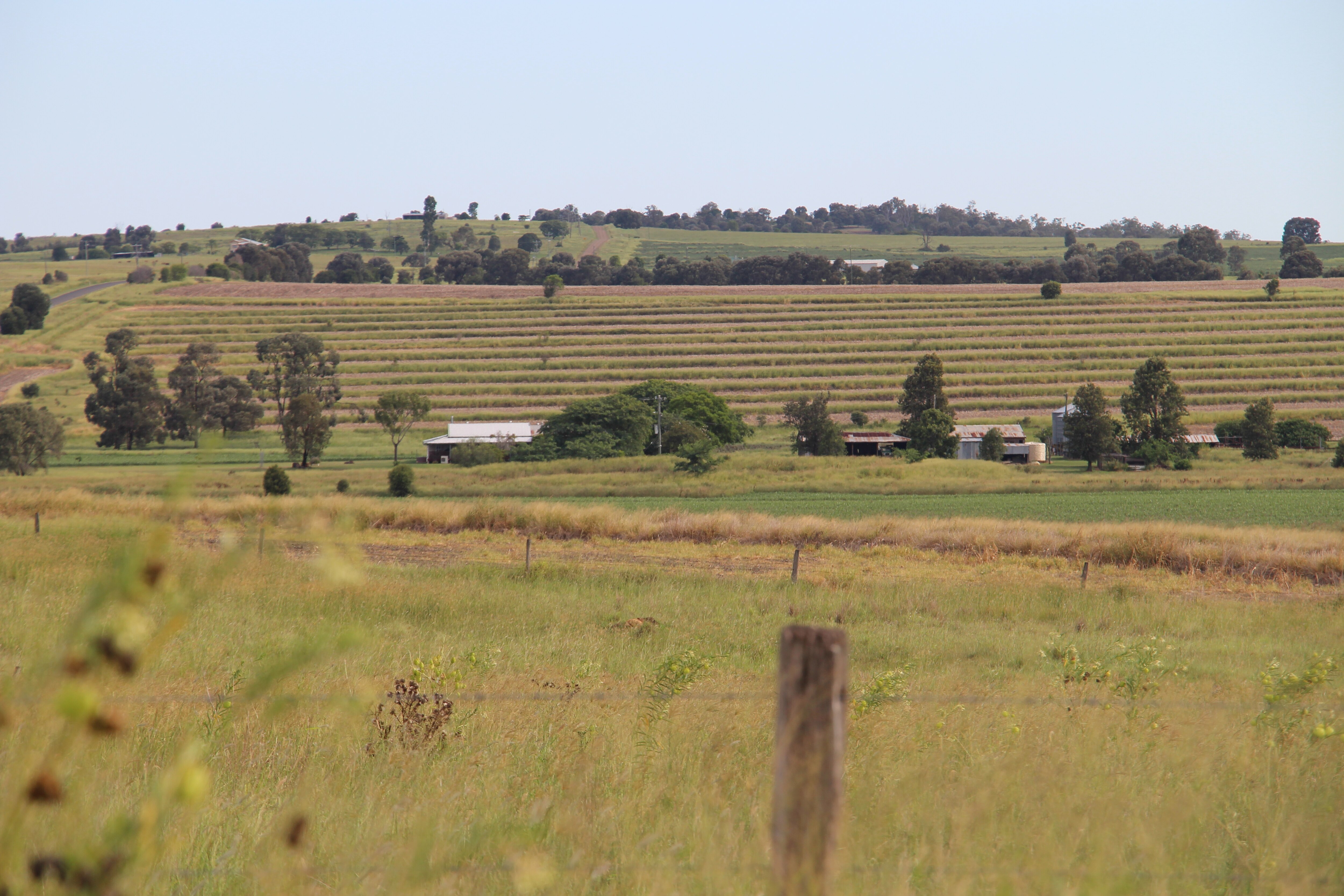 A rural landscape with fence in the foreground and hills in the background