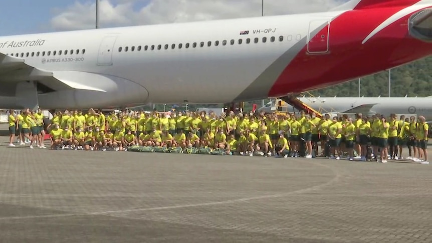 Más de 250 miembros de la escuadra olímpica australiana parados debajo de un avión de Qantas