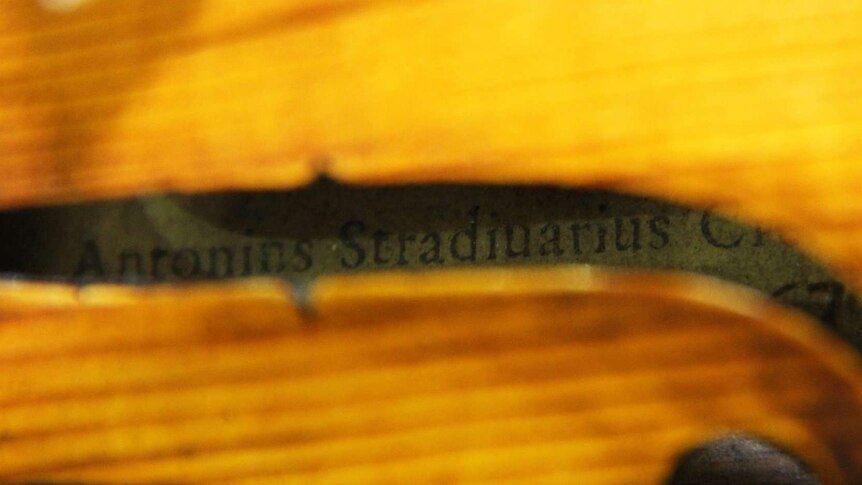 Looking inside an old viola to adhesive label with name 'Antonins Stradiuarius'.