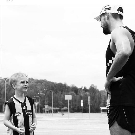 small boy looking up to a footballer.