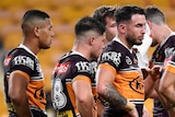 Brisbane Broncos players, with Darius Boyd front and centre, stand with their hands on their hips, looking disappointed.