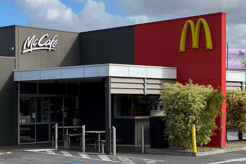 The outside of a McDonald's restaurant on an autumn day with blue sky and clouds.