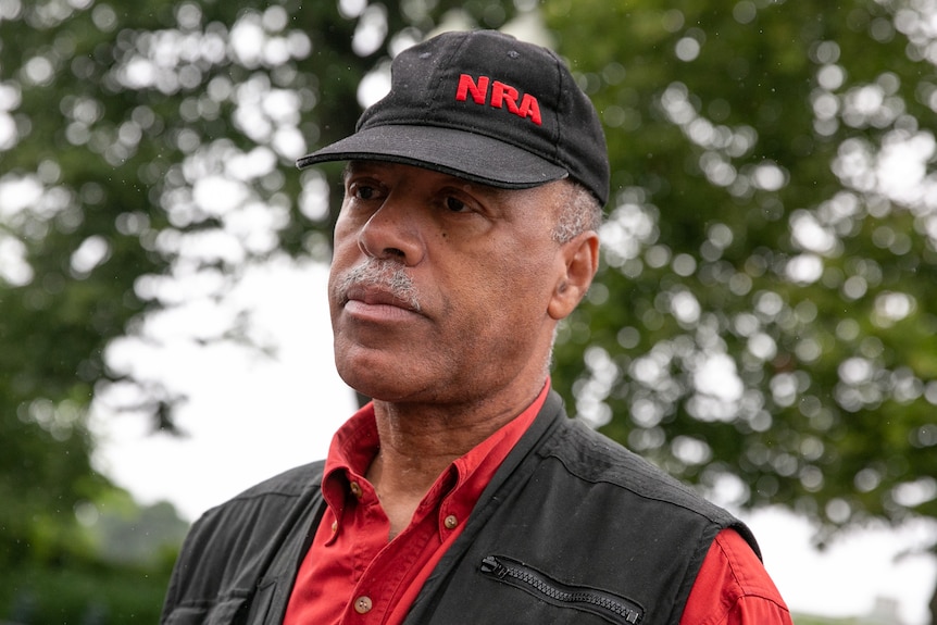 A man wearing a cap and a red shirt is interviewed outside the US Supreme Court. 