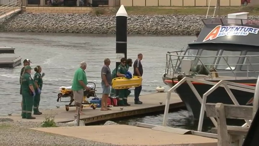 A boat docking with people waiting 