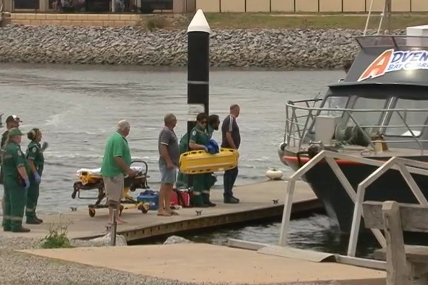 A boat docking with people waiting 