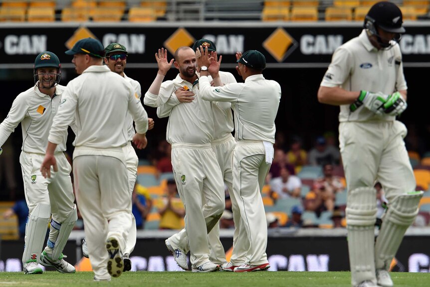 Nathan Lyon is congratulated after taking the wicket of Martin Guptill