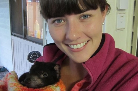 Researcher Emma Peel with a Tasmanian devil joey.